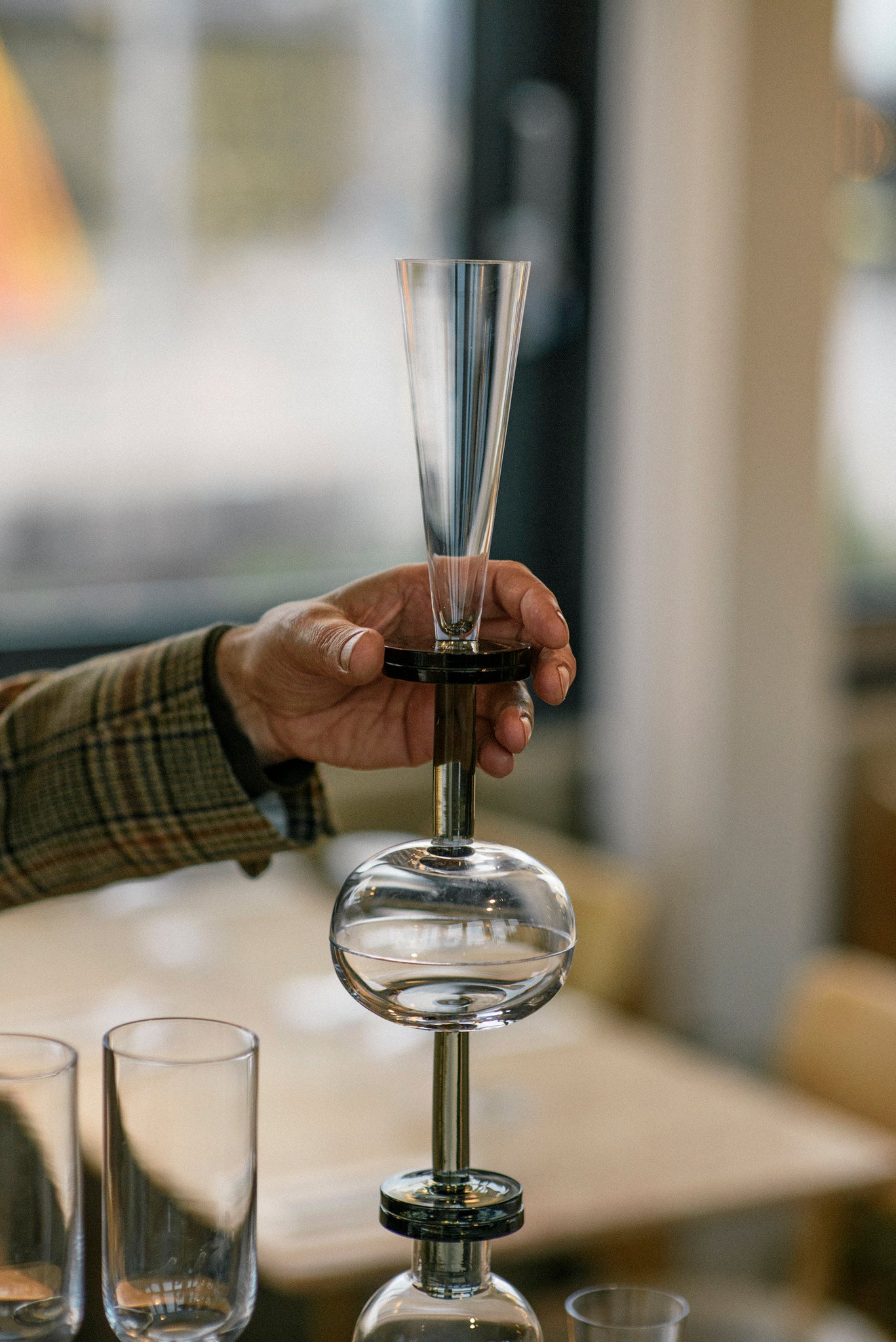 Champagne and wine glasses stacked with a hand holding the topmost one